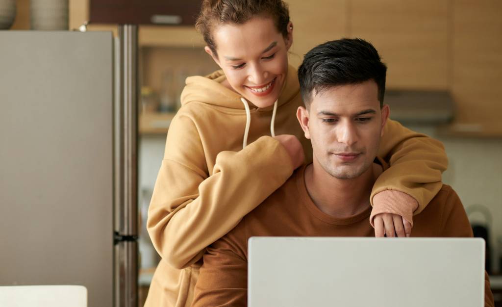 Couple using laptop at home